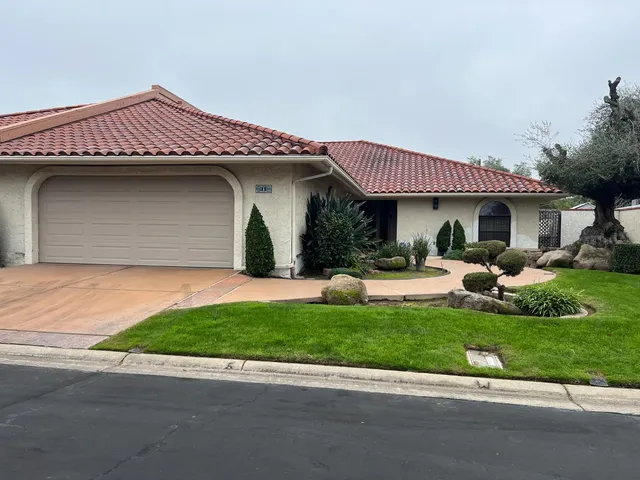 a front view of a house with a garden and plants