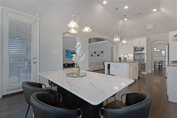 a kitchen with a table chairs sink and cabinets