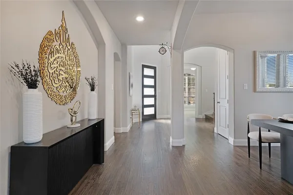 a view of a hallway with wooden floor and stairs