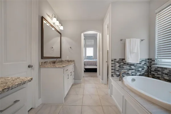 a bathroom with a granite countertop sink a toilet and bathtub