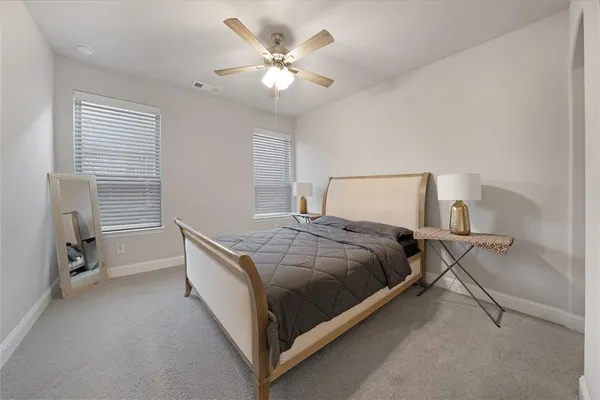 a bedroom with a bed and a ceiling fan