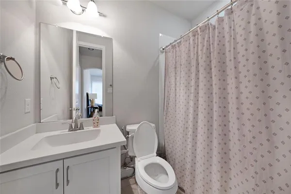 a bathroom with a toilet a sink and a mirror