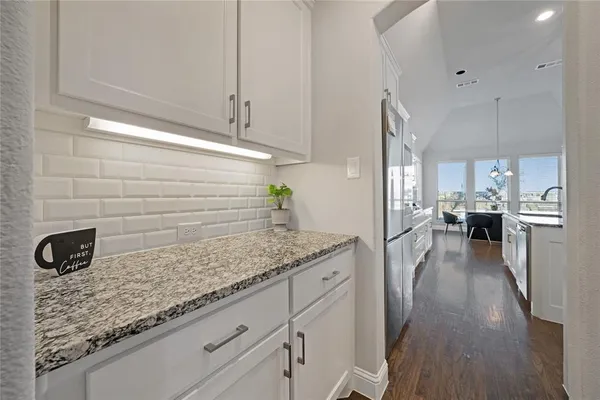 a kitchen with kitchen island granite countertop a sink a counter space appliances and cabinets