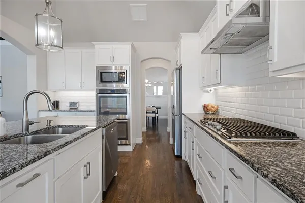 a kitchen with stainless steel appliances granite countertop a sink stove and refrigerator