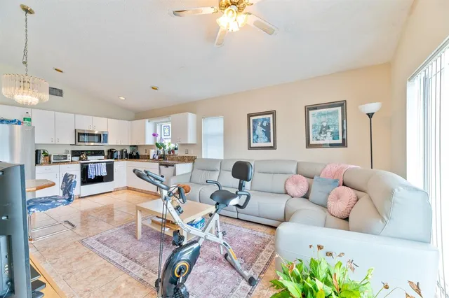 a living room with furniture kitchen view and a chandelier