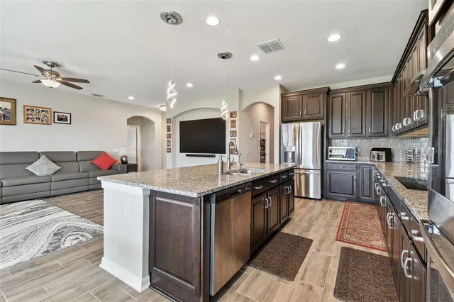 a bathroom with a granite countertop sink a toilet a mirror and shower