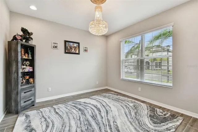 a view of a hallway with wooden floor and a living room