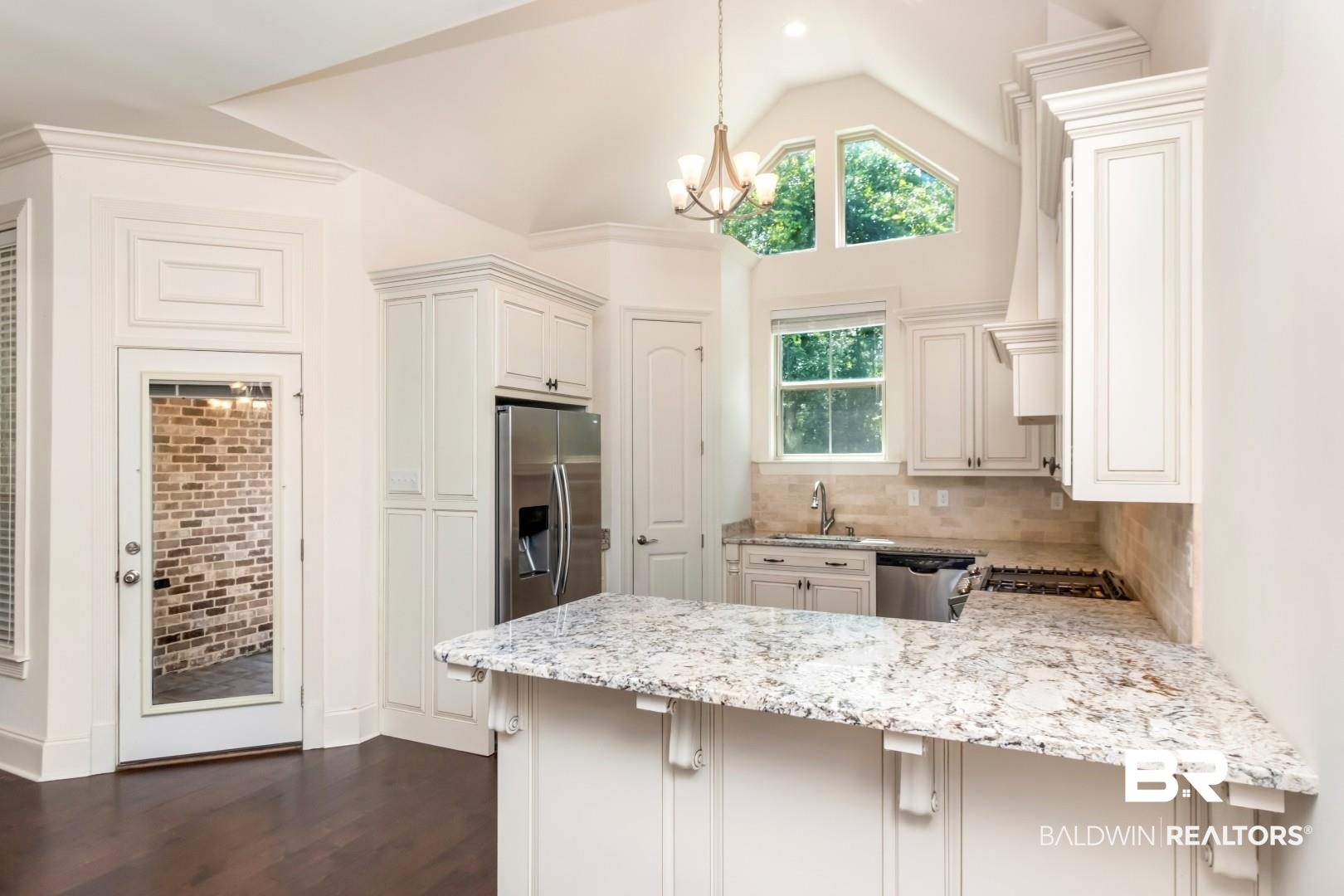 3528 Rue Royal Mobile, AL 36693 - Photo 7 of 53 Kitchen featuring a peninsula with granite countertops, white cabinetry, stainless steel appliances, and wood-finish flooring