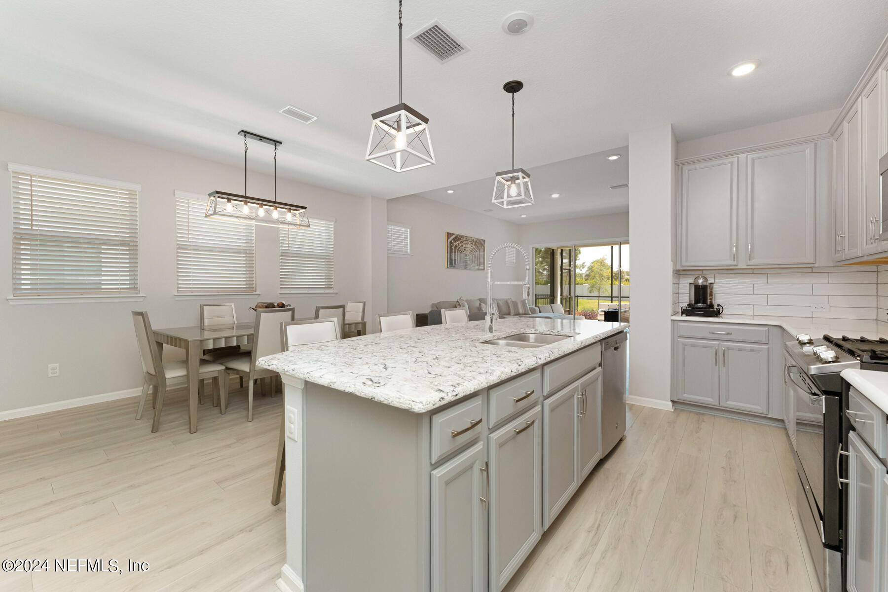 10279 Innovation Way Jacksonville, FL 32256 - Photo 9 of 42 a large kitchen with kitchen island a sink table and chairs