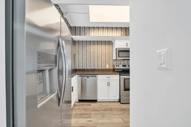 a kitchen with stainless steel appliances a refrigerator and cabinets