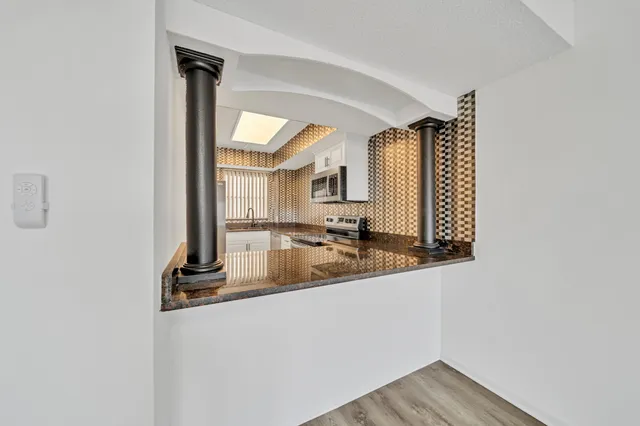 a kitchen with granite countertop a stove and a sink