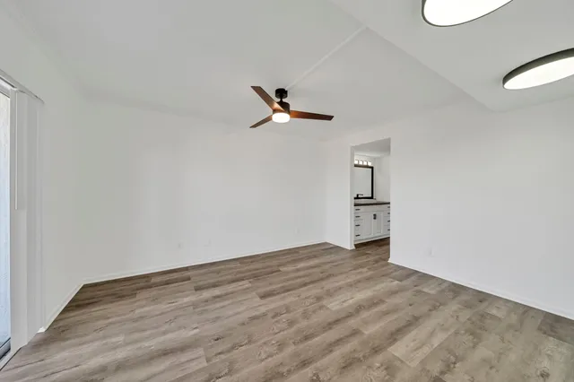 a view of a livingroom with a ceiling fan wooden floor and a ceiling fan