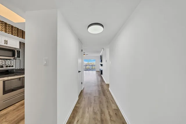 a view of a hallway with wooden floor and staircase