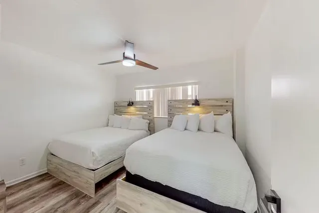 a bedroom with two beds and window