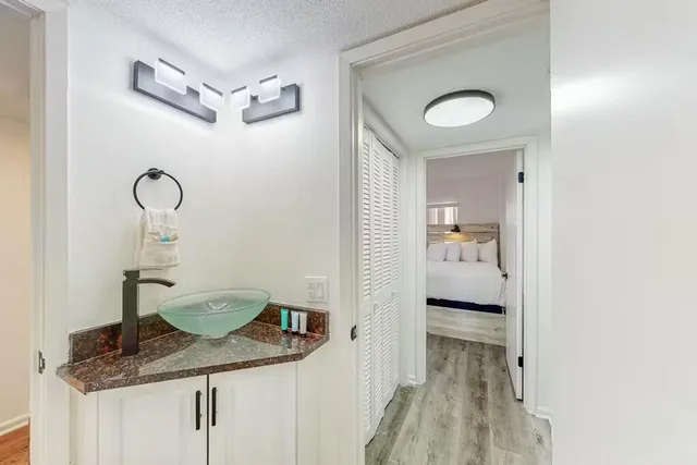 a en suite bathroom with a granite countertop sink and a mirror