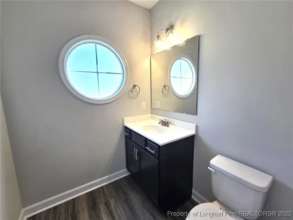 a bathroom with a toilet mirror vanity and vanity