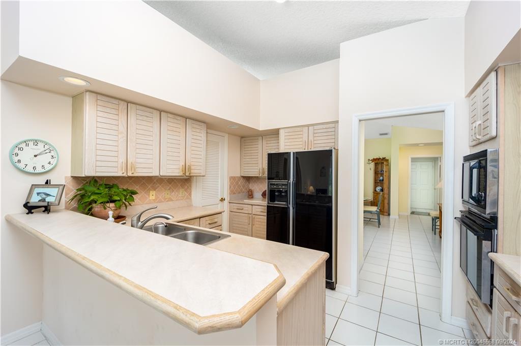 Undisclosed Address Stuart, FL 34997 - Photo 31 of 52 a kitchen with stainless steel appliances a refrigerator sink and cabinets