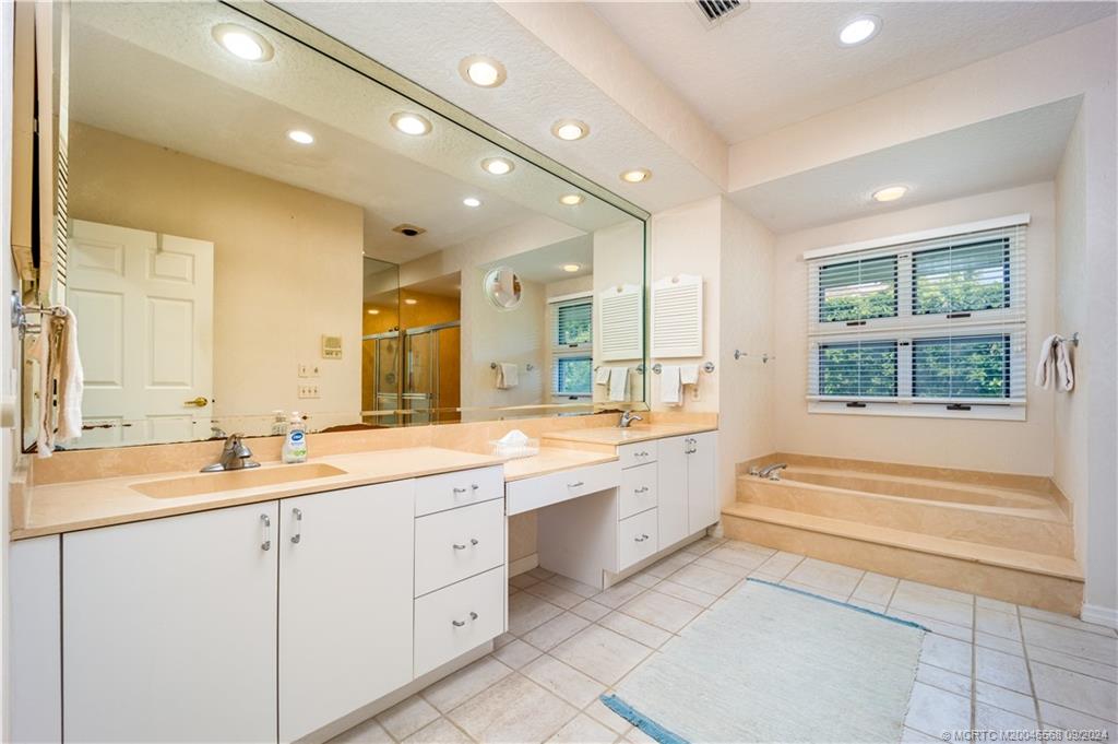 Undisclosed Address Stuart, FL 34997 - Photo 37 of 52 a bathroom with a sink vanity tub shower and a mirror