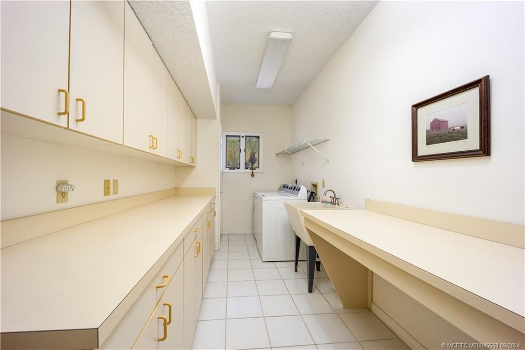 Undisclosed Address Stuart, FL 34997 - Photo 45 of 52 a utility room with cabinets washer and dryer