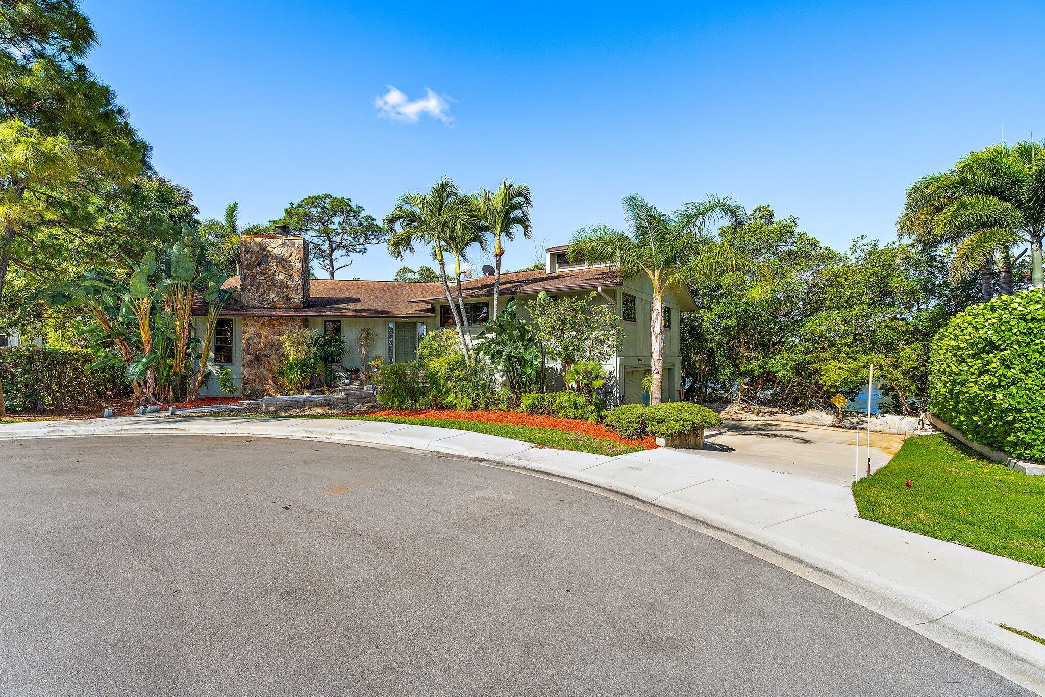 702 Warren Drive Jupiter, FL 33458 - Photo 13 of 76 a view of a house with a yard and potted plants