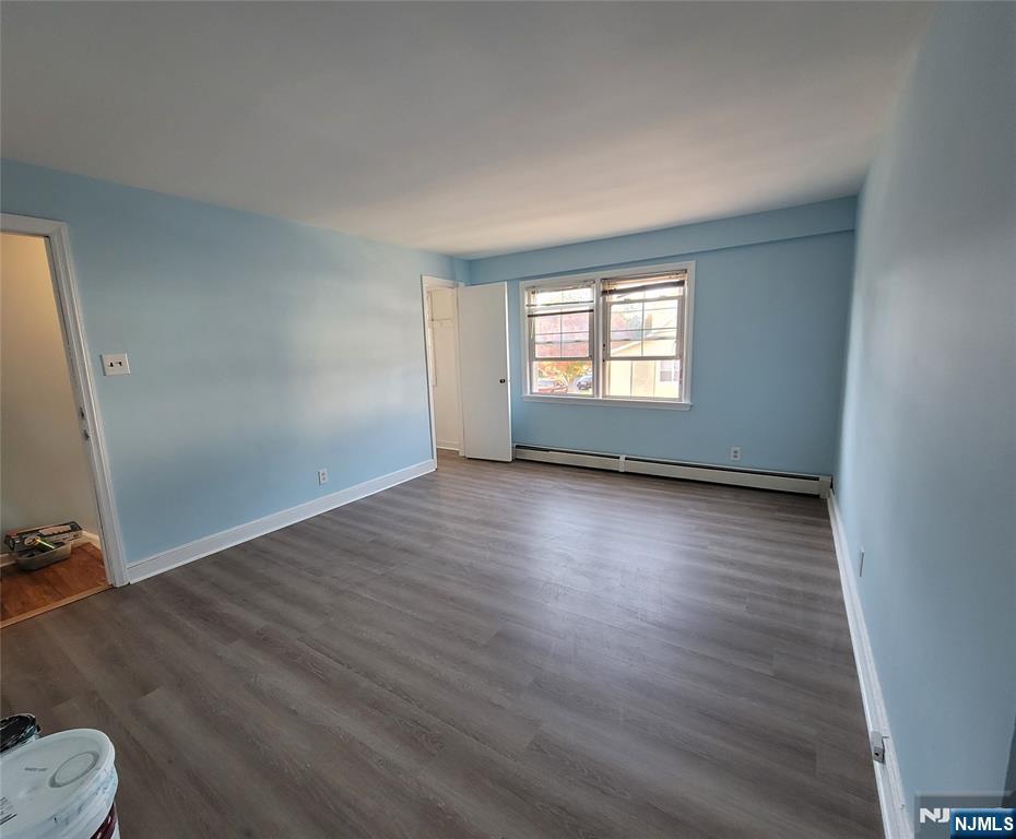 772 Devon Street, Unit 2 Kearny, NJ 07032 - Photo 6 of 10 an empty room with wooden floor and windows