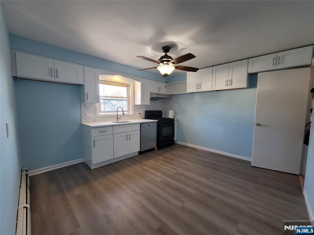 772 Devon Street, Unit 2 Kearny, NJ 07032 - Photo 9 of 10 a kitchen with stainless steel appliances a sink cabinets and wooden floor