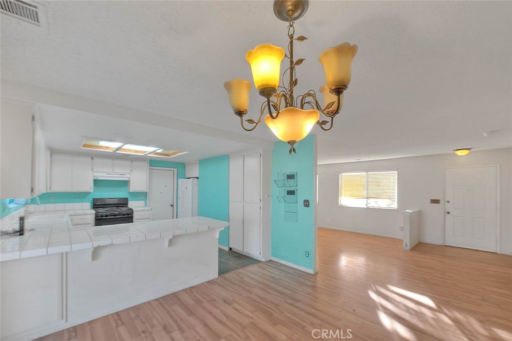 14811 Kingsdale Road Apple Valley, CA 92307 - Photo 14 of 57 a view of a kitchen with a sink and a chandelier