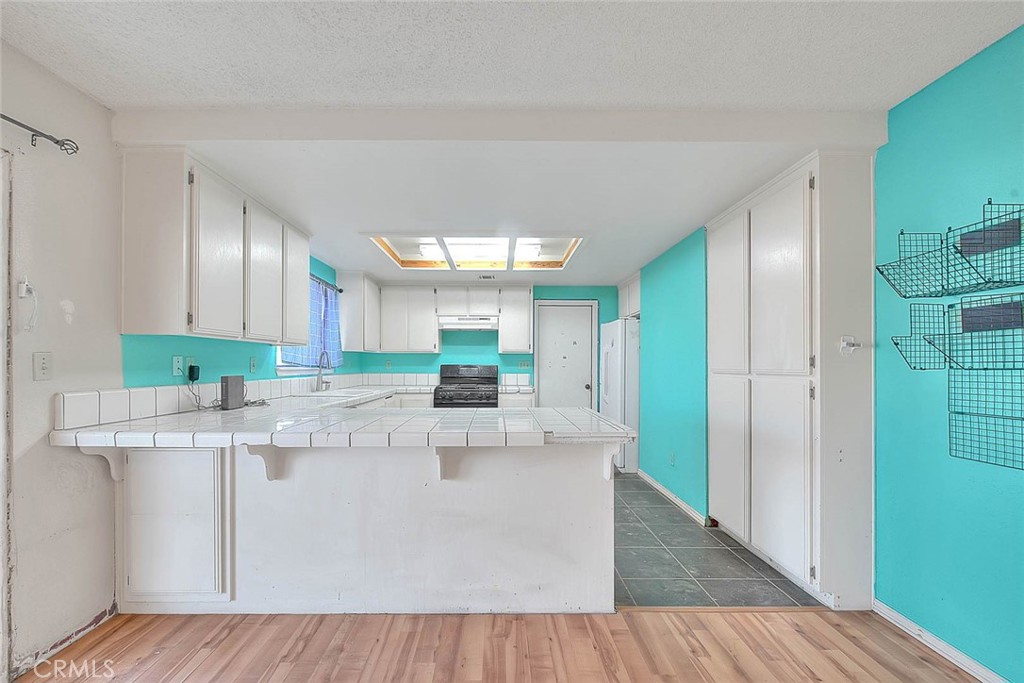 14811 Kingsdale Road Apple Valley, CA 92307 - Photo 15 of 57 a large kitchen with stainless steel appliances granite countertop a white cabinets and a chandelier