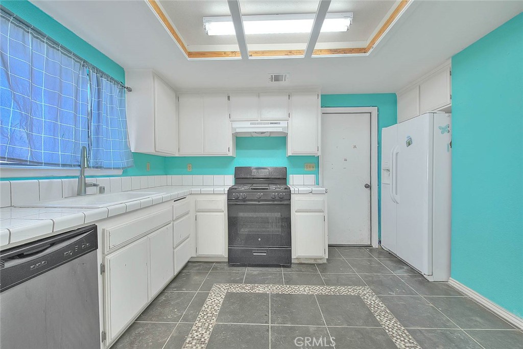 14811 Kingsdale Road Apple Valley, CA 92307 - Photo 16 of 57 a kitchen with a sink cabinets and appliances