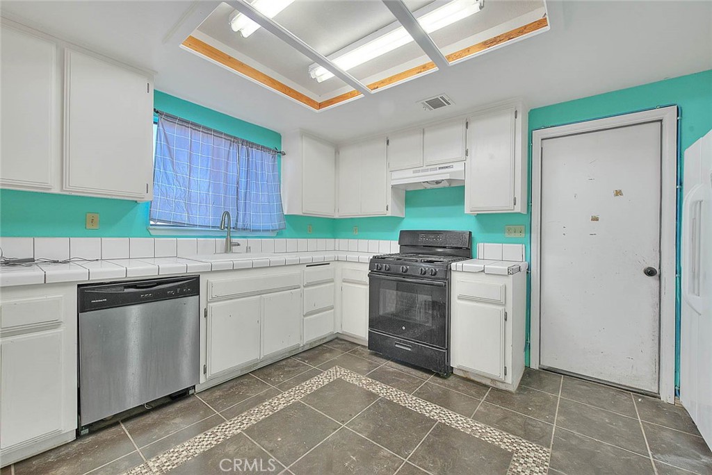 14811 Kingsdale Road Apple Valley, CA 92307 - Photo 17 of 57 a kitchen with granite countertop a sink and a stove top oven