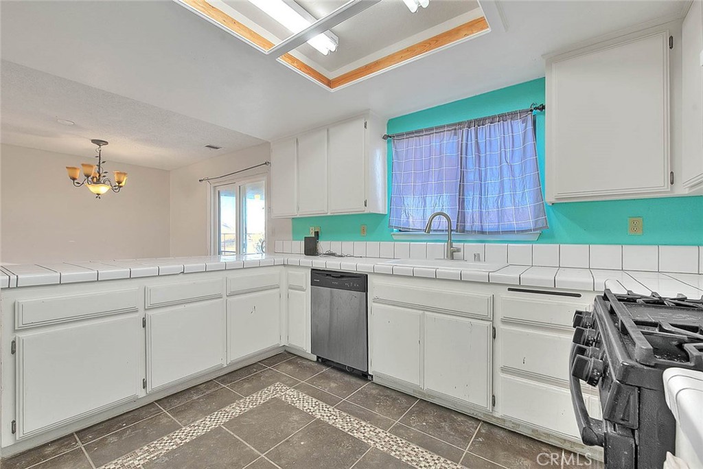14811 Kingsdale Road Apple Valley, CA 92307 - Photo 19 of 57 a kitchen that has a sink and a stove in it