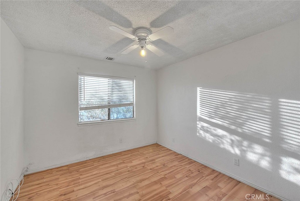 14811 Kingsdale Road Apple Valley, CA 92307 - Photo 26 of 57 a view of an empty room with wooden floor and a window
