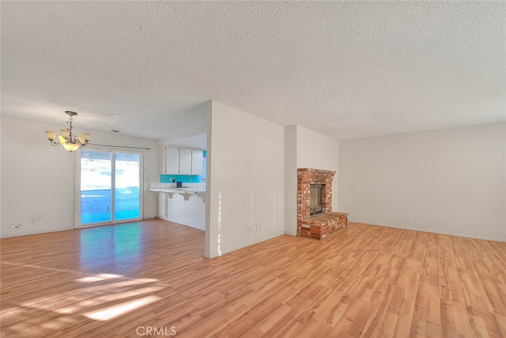 14811 Kingsdale Road Apple Valley, CA 92307 - Photo 7 of 57 a empty room with a window and wooden floor
