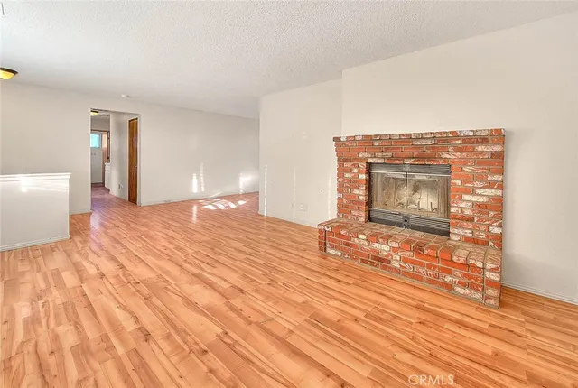 a view of empty room with wooden floor and fireplace