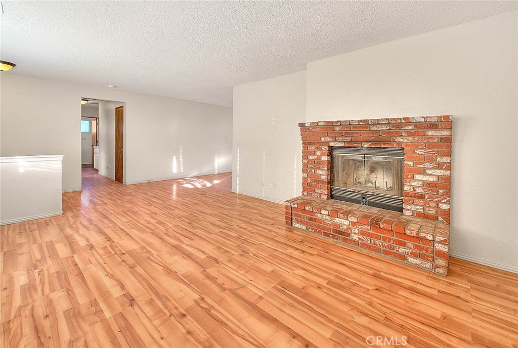 14811 Kingsdale Road Apple Valley, CA 92307 - Photo 10 of 57 a view of empty room with wooden floor and fireplace