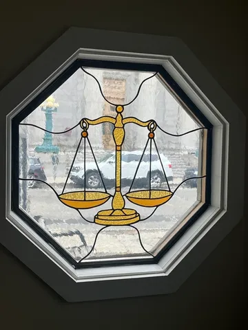 a view of an empty room with wooden floor and furniture