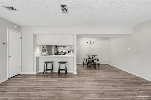 a kitchen with stainless steel appliances a table and chairs in it