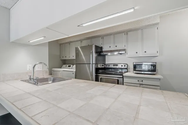 a kitchen with stainless steel appliances granite countertop a sink a stove and a refrigerator