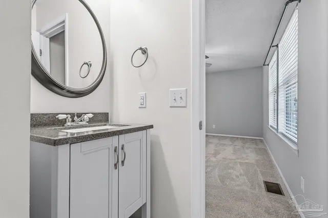a view of an empty room with a chandelier fan