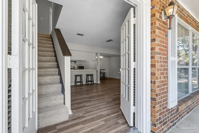 a view of a hallway with wooden floor and staircase