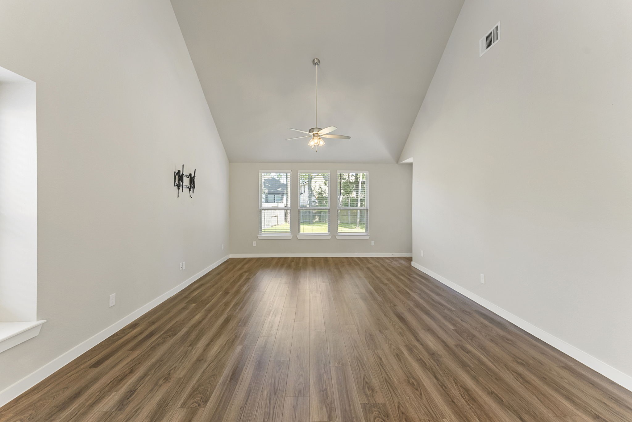 421 Soapberry Tree Court Conroe, TX 77318 - Photo 17 of 50 wooden floor in an empty room with a window