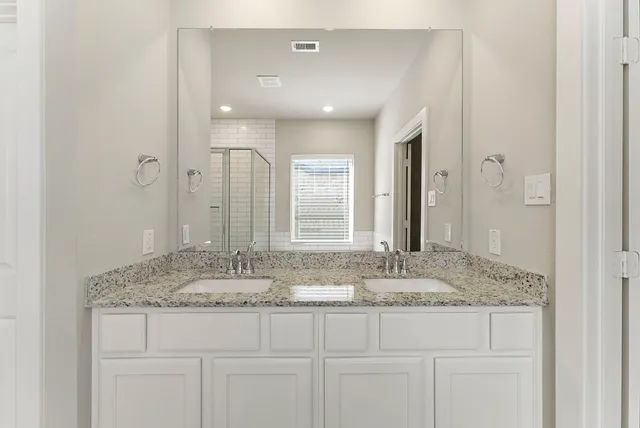 a bathroom with a granite countertop tub sink and mirror