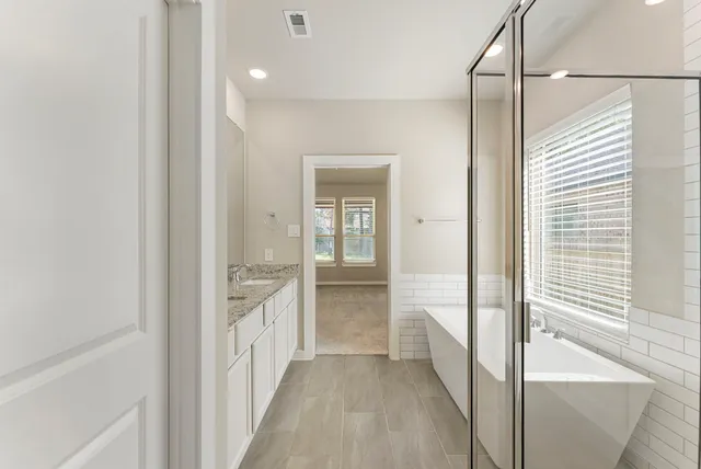 a bathroom with a granite countertop sink and mirror with window