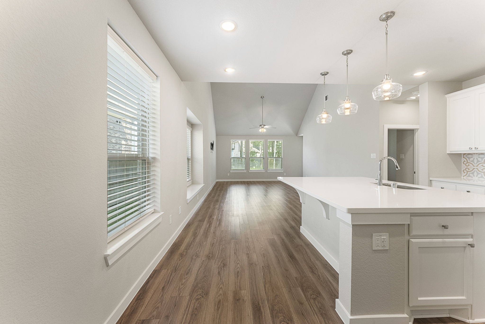 421 Soapberry Tree Court Conroe, TX 77318 - Photo 7 of 50 a view of a kitchen with kitchen island a sink wooden floor and a large window