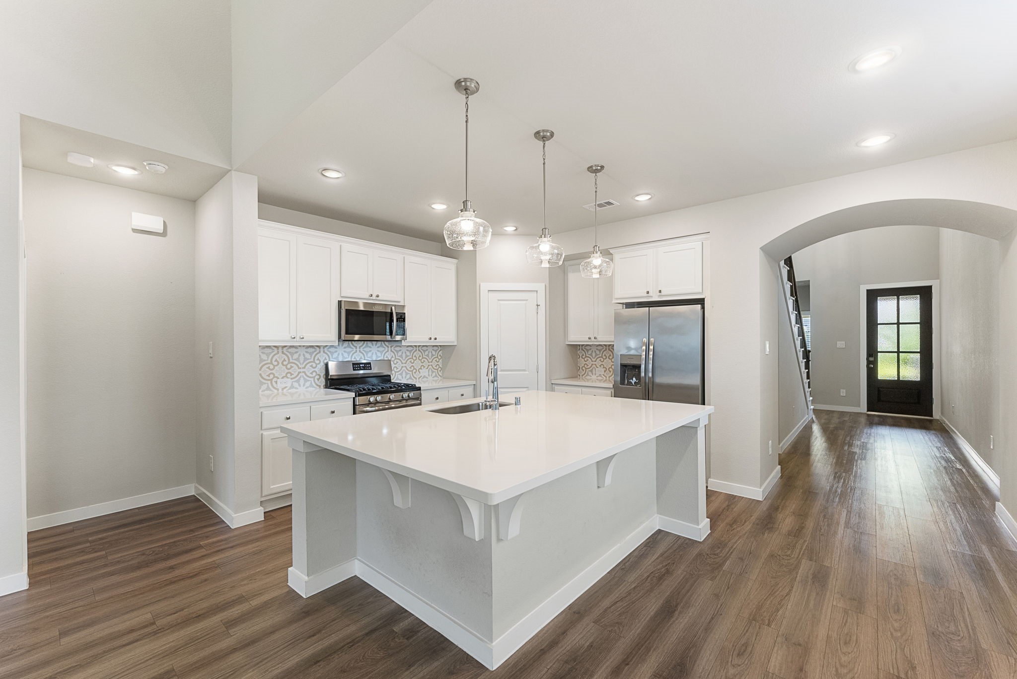 421 Soapberry Tree Court Conroe, TX 77318 - Photo 9 of 50 a large white kitchen with wooden floor and a refrigerator