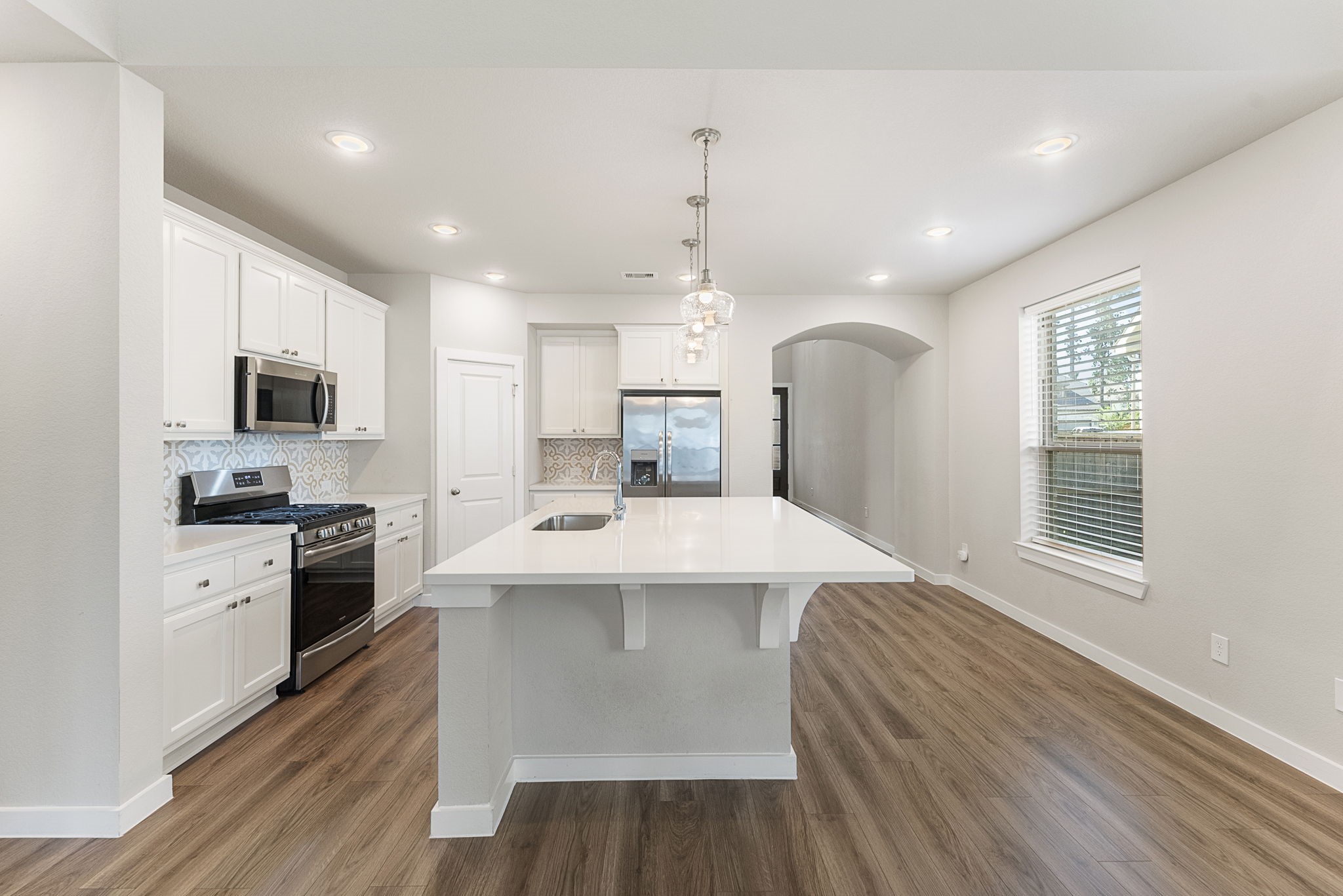 421 Soapberry Tree Court Conroe, TX 77318 - Photo 10 of 50 a large kitchen with kitchen island a sink a center island stainless steel appliances and cabinets