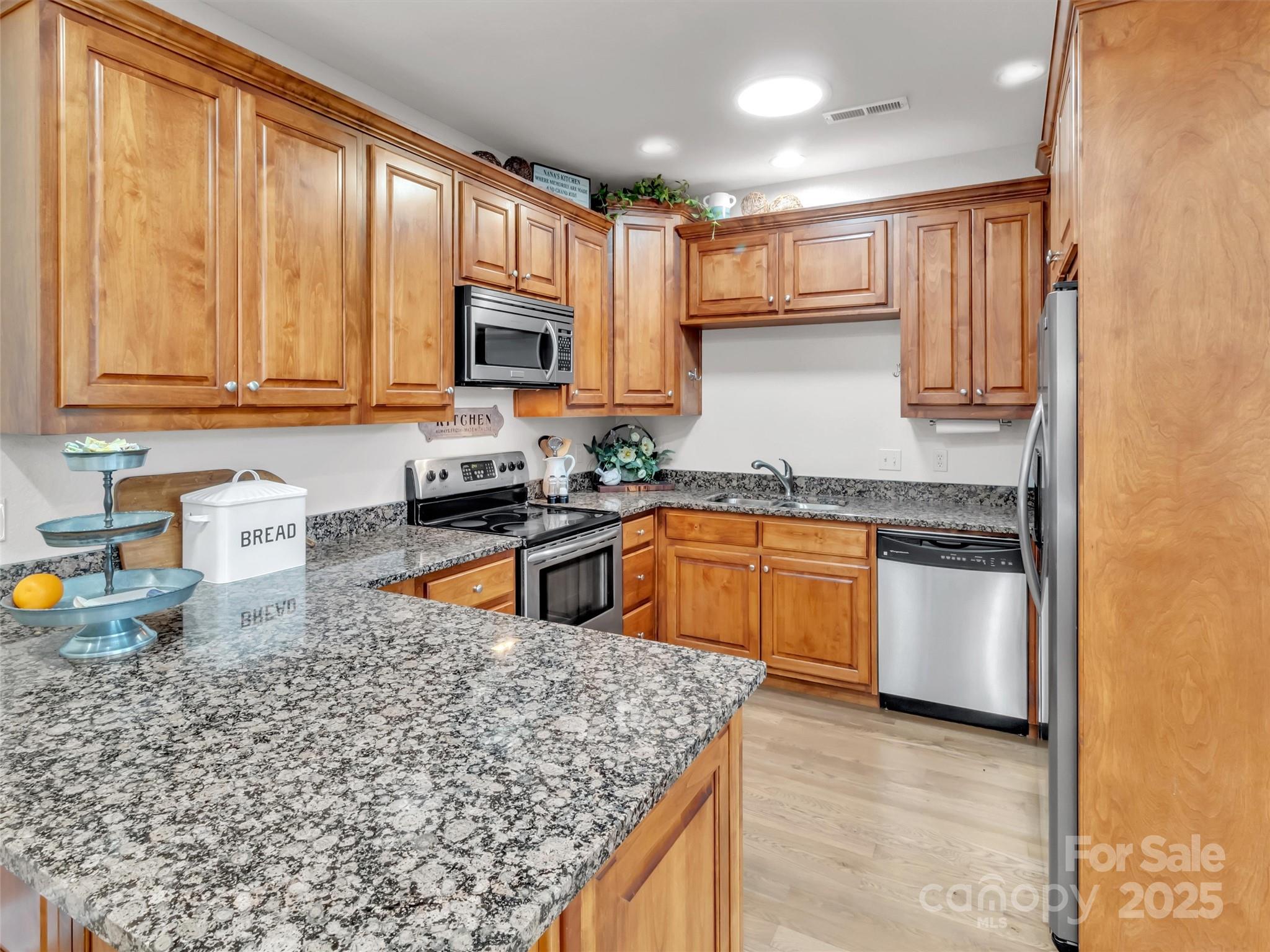 166 Amaroo Ridge, Unit 5 6 Sylva, NC 28779 - Photo 26 of 48 a kitchen with stainless steel appliances granite countertop a stove a sink and a microwave