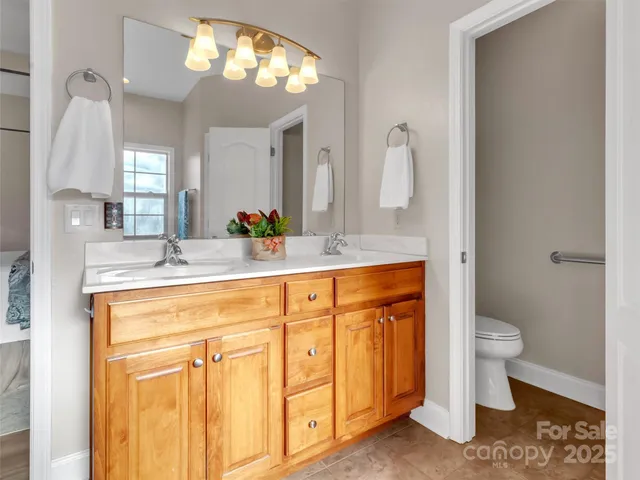 a bathroom with a sink a toilet and a mirror