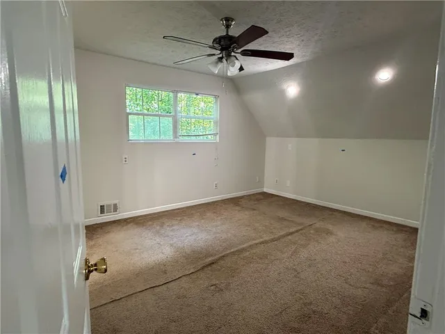 an empty room with fan and windows
