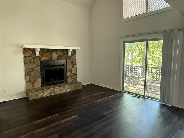 a living room with wooden floor and a fireplace